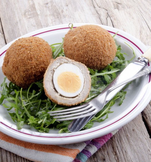 scotch eggs on a plate with rocket salad